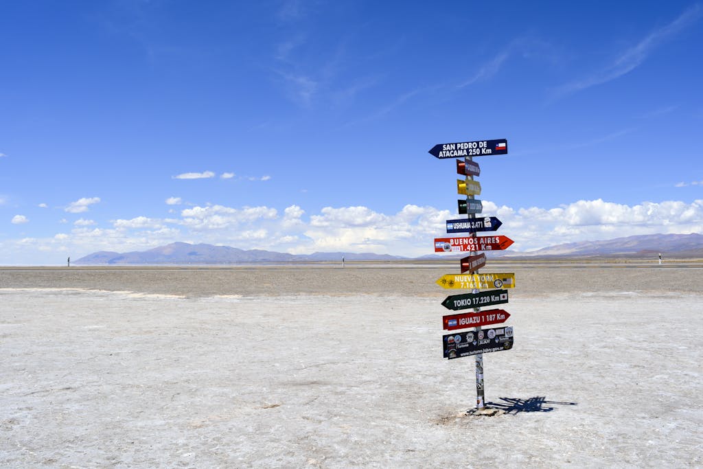 A bright signpost stands in a vast arid landscape with clear blue skies in Argentina.